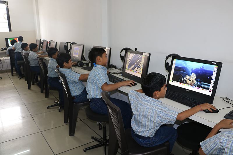 Students of Lucky Public School learning computer skills in the computer lab, working on desktops to enhance digital literacy and coding knowledge.